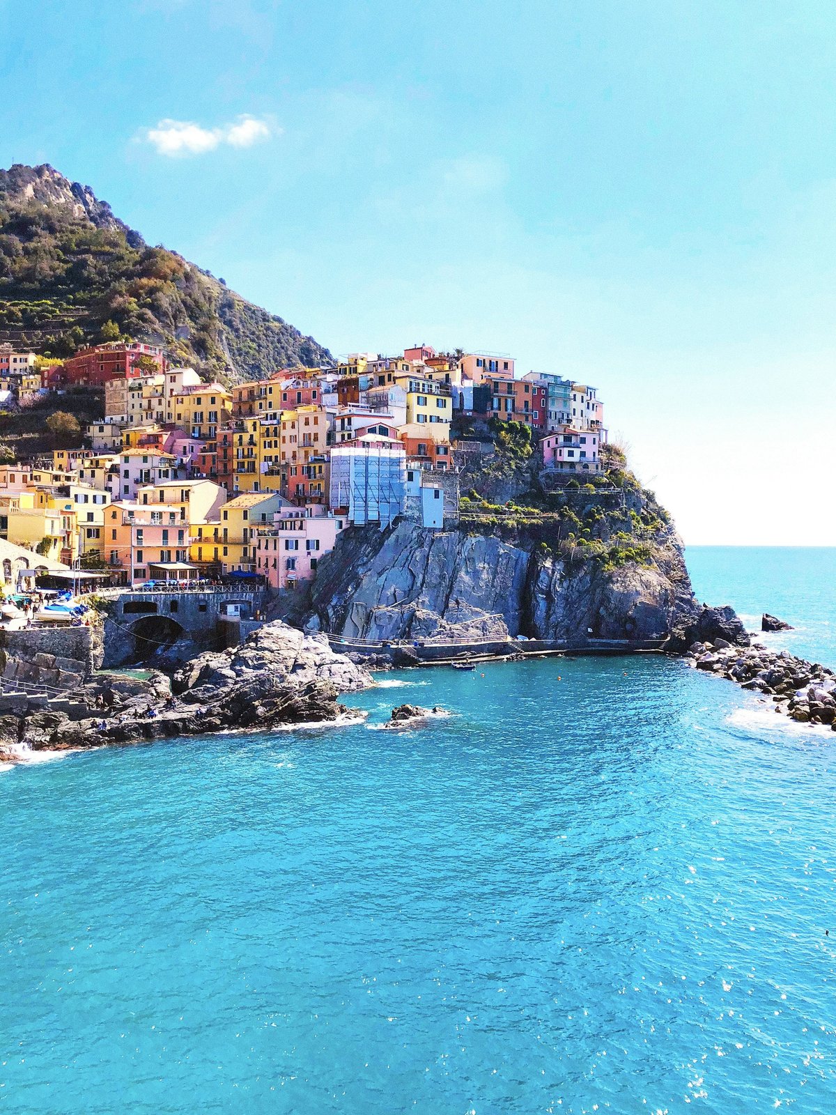 Colorful clifftop village of Manarola on the Italian coast above turquoise water